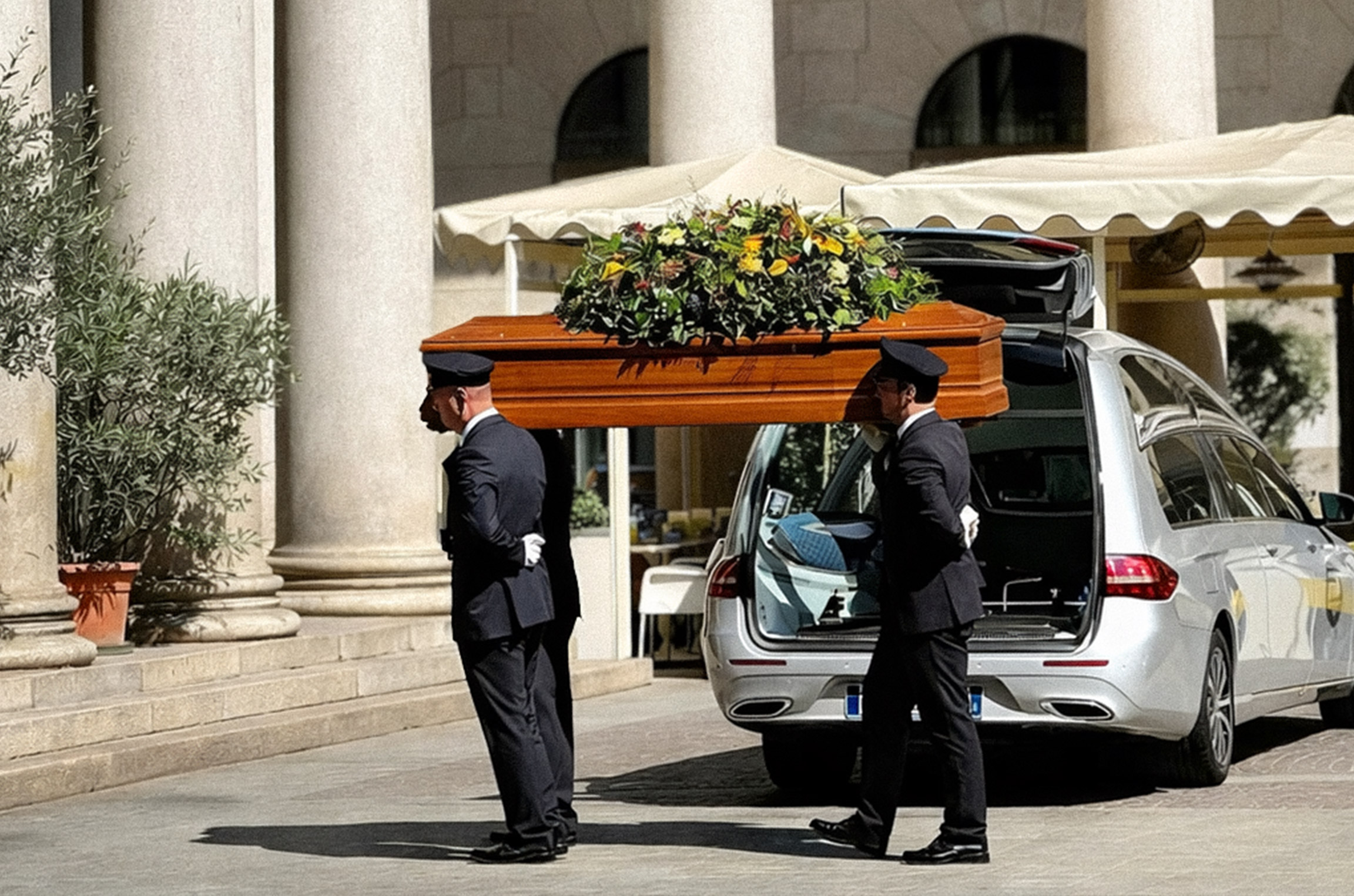 Auto funebre con portatori in divisa