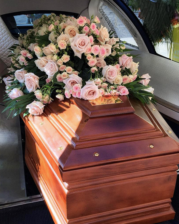Cofano con composizione di rose sul carro funebre