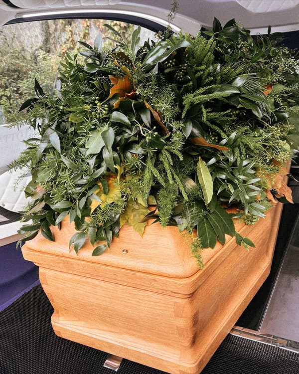 Cofano con composizione di verde e fiori
