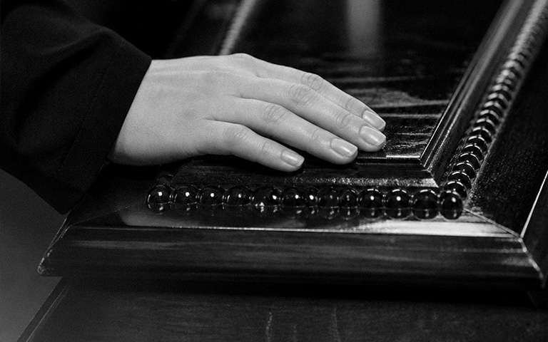 Mano su cofano scuro, bianco e nero